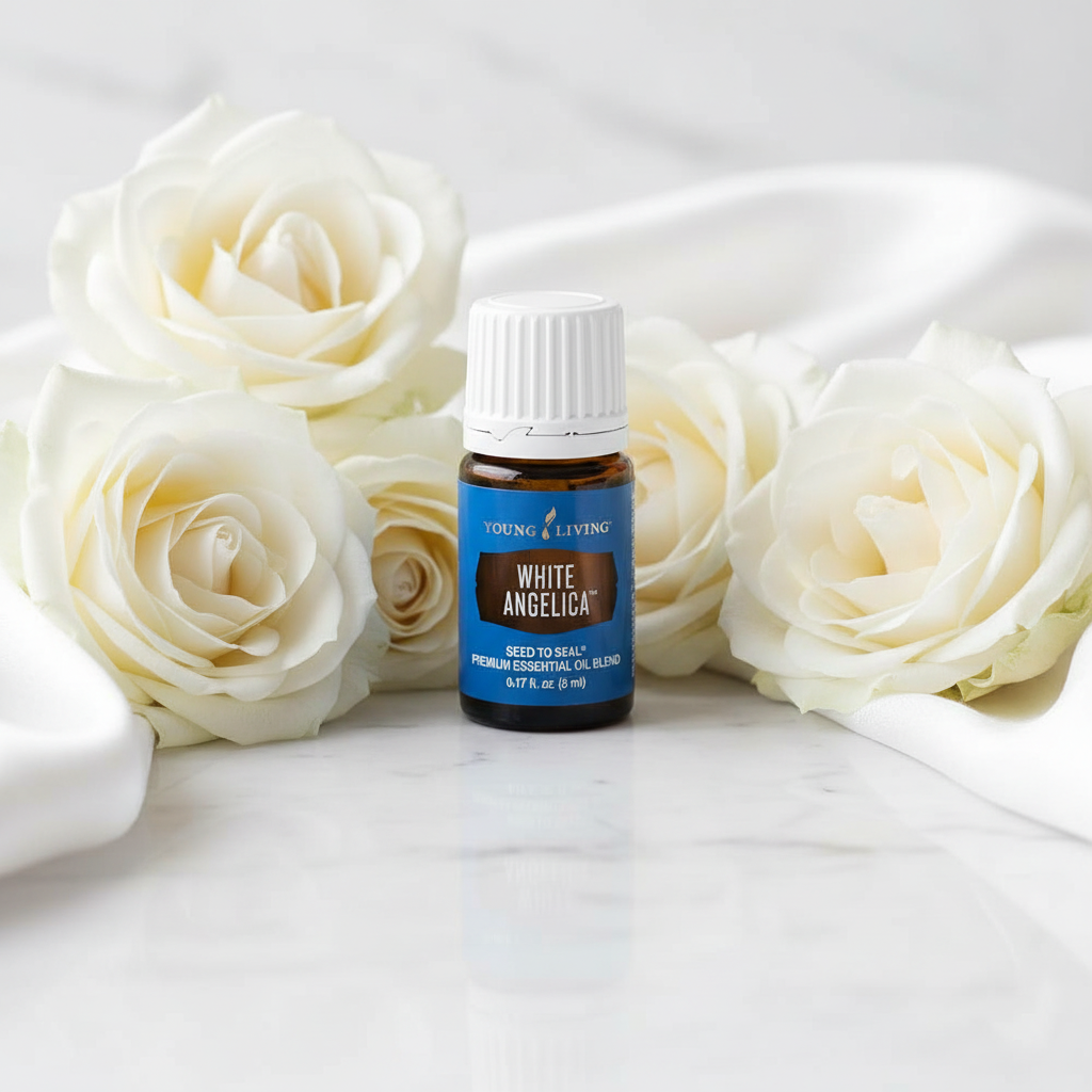 Young Living White Angelica oil bottle with white roses on marble spa setting