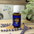 Young Living Freedom oil bottle with lavender and frankincense on wooden surface