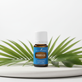 Dorado Azul essential oil bottle with tropical leaves on spa surface