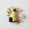 Frankincense roll-on flat lay with crystals and botanicals