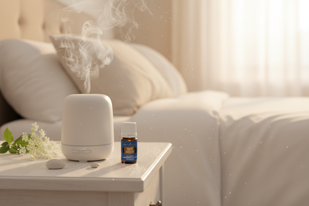 Young Living White Angelica oil bottle next to diffuser in cozy white bedroom