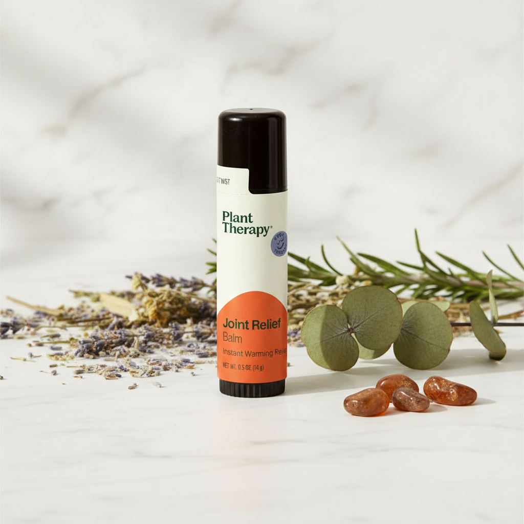 Plant Therapy Joint Relief Balm on marble with herbs and amber stones